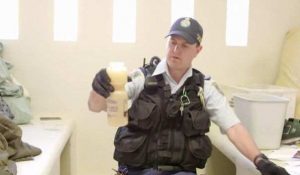 A Corrections Officer seizing illegal homemade alcohol as seen on Australia Behind Bars.